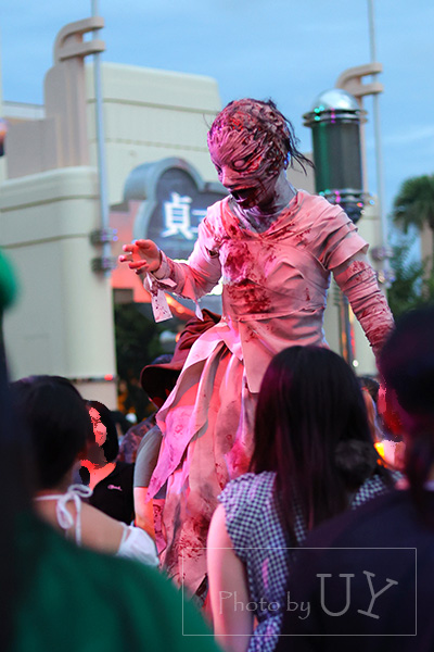 ハロウィーンホラーナイト2026 包帯を巻いたミイラ型ゾンビが観客に手を伸ばす