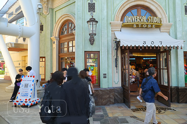 ユニバーサルスタジオストア前のグッズ販売入店整理券看板と整理券を取ろうとしている人たち